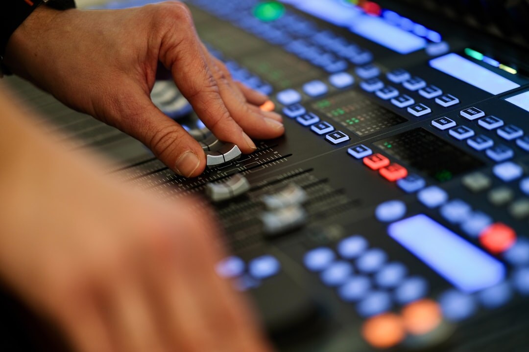 Hands operating a live video switcher panel with camera preview buttons
